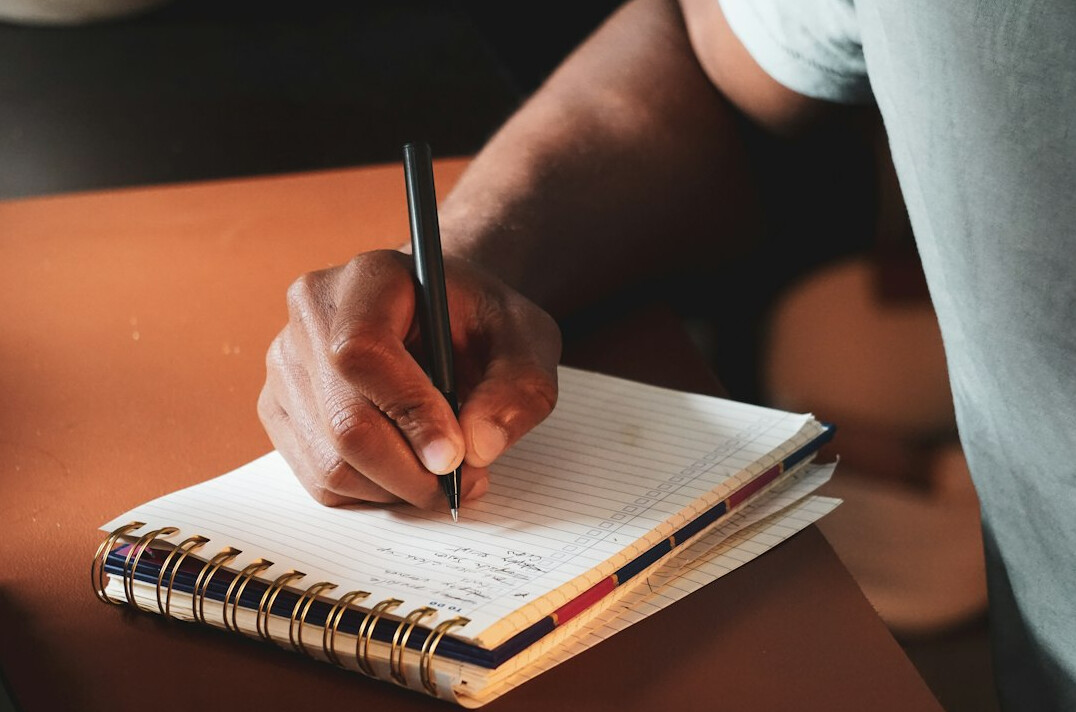 person writing in journal